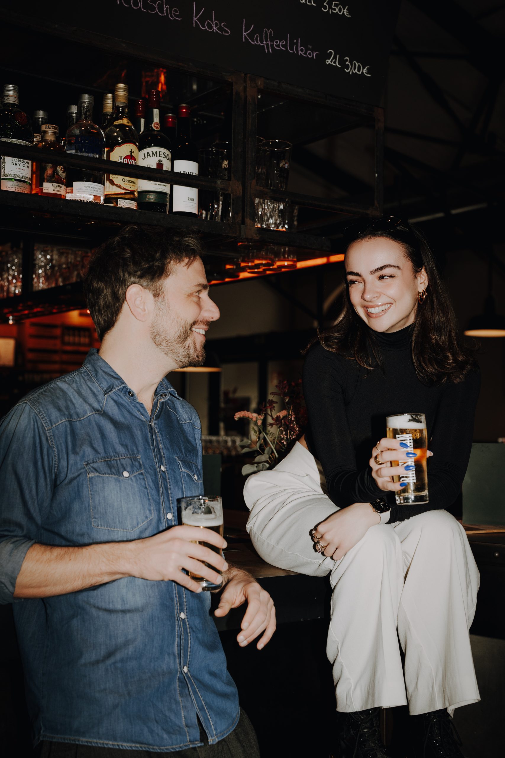 Junger Mann und Frau in Bar mit gezapftem Ratsherrn Bier in der Hand.